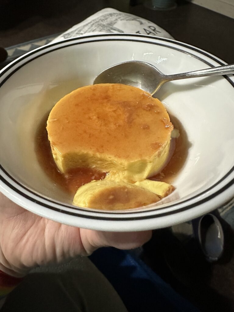 A spoon slice of flan scooped away so you can see the silky interior